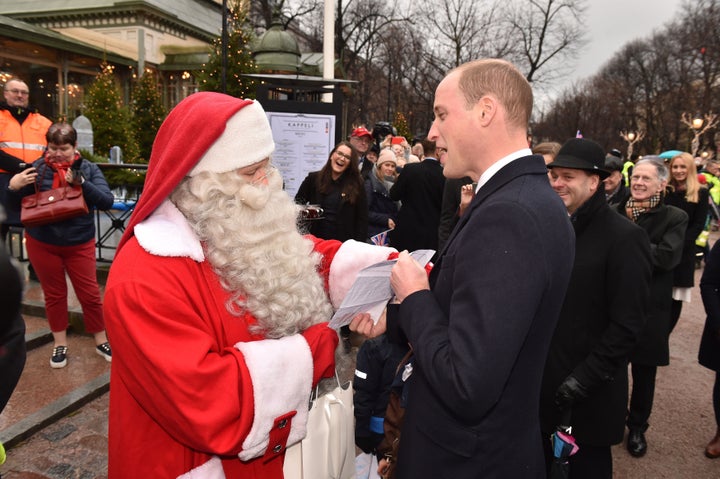 The Duke of Cambridge hands Prince George's Christmas wish list to Father Christmas at a market in Helsinki, Finland. 