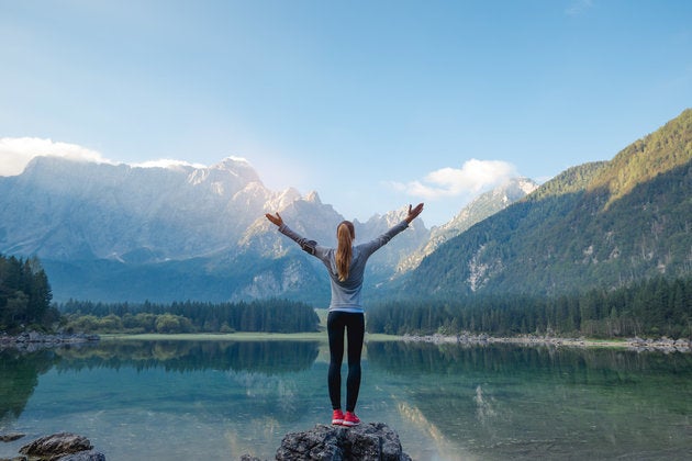 Woman standing on the rock. Success concept. Getty