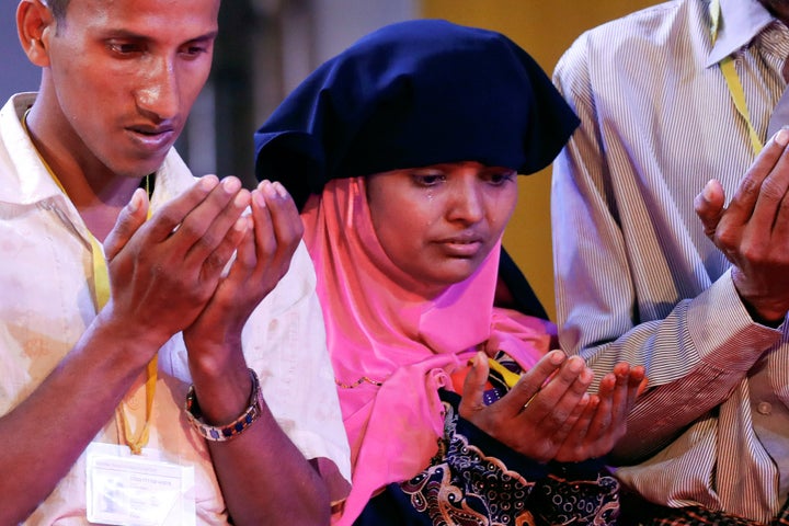 Tears run down the face of a woman as she and others pray during their meeting with Pope Francis in Dhaka, Banglade