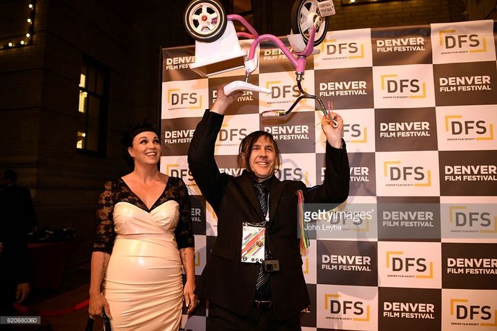 <p>Novick holding up his most prized possession at the Denver Film Festival premiere of his film </p>