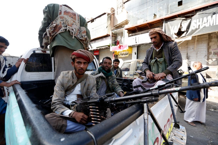 Houthi rebel fighters wait outside former President Ali Abdullah Saleh's residence in Sanaa on Monday.