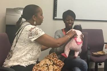 Hannah White, right, with her five-week old daughter Maddilyn, meets with case manager Denise Duckett last month during her postpartum visit in Asheville, North Carolina. White was a patient in a statewide network of pregnancy medical homes that serves expectant mothers in Medicaid. 