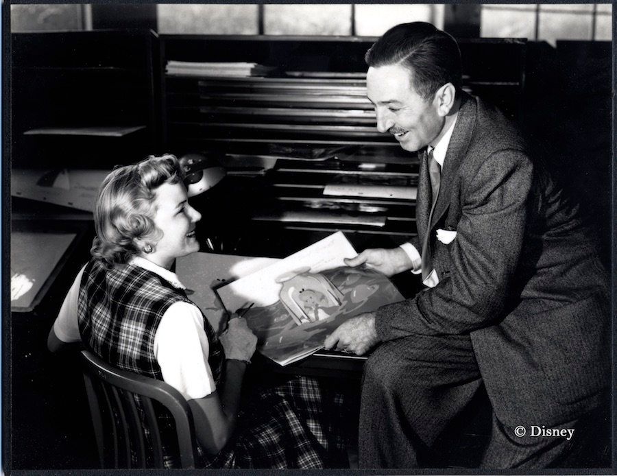 Ginni Mack, who worked as an inker, and Walt Disney review production artwork from "Alice in Wonderland," circa 1950.