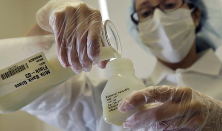 A lab technician at Mothers' Milk Bank Northeast, in Massachusetts, pours donated breast milk into a plastic bottle for pasteurization. 