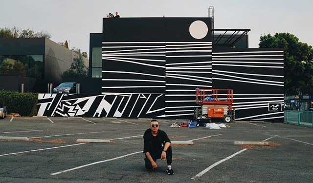 Tommii Lim in front of the Belzberg Architects' office in Santa Monica, featuring four new murals by the artist. “#mural 1 of 4 done for @belzberg_architects! #tommiilim #blackandwhite #art #waves 📸 @christopherdetails” Image courtesy of the artist at @Tommii on Instagram.
