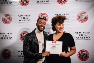 From left to right cast member Etienne Maurice and Director Twinkie Bryd holding the award given by the African American Films Critic Association