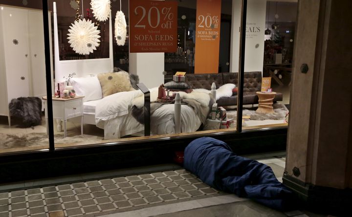 The number of homeless children in Britain is at a ten year high; a homeless man is pictured sleeping outside a furniture shop in central London