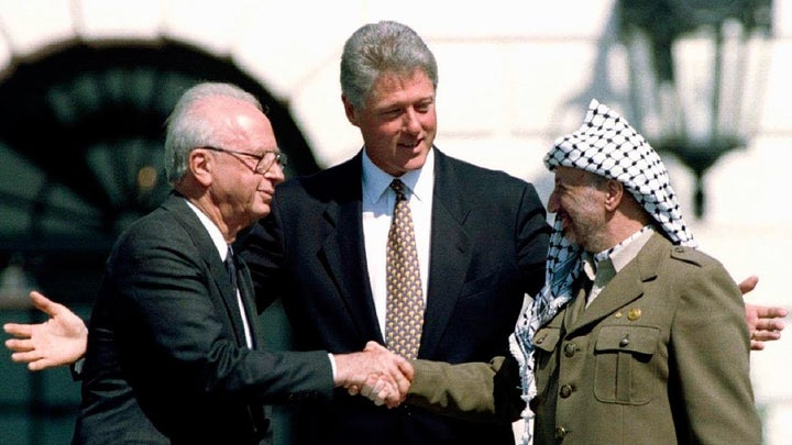 President Clinton nudges two old enemies toward each other - Israeli Prime Minister Yitzhak Rabin and Chairman of the Palestine Liberation Organization Yasser Arafat - at the signing of the Oslo Accords in September 1993. Rabin and Arafat were awarded the Nobel Peace Prize for their efforts. Rabin was assassinated two years later by an Israeli ultranationalist who opposed the peace agreement..