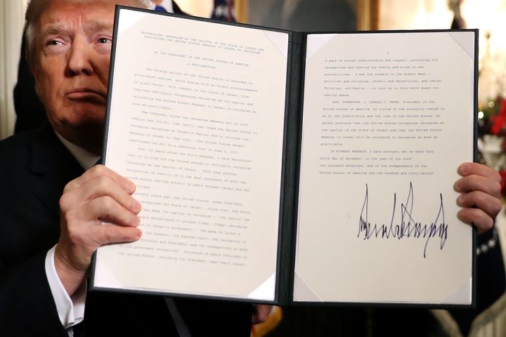 Trump holds up a proclamation that the US government will formally recognise Jerusalem as the capital of Israel