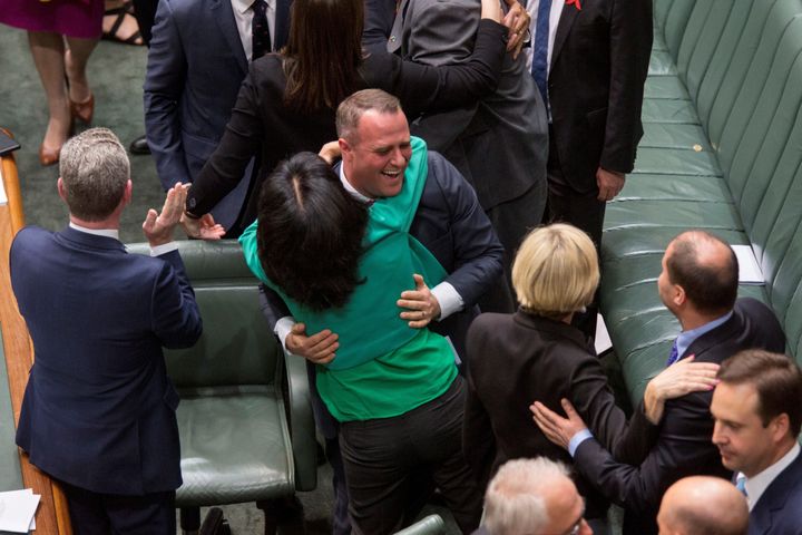 Members of Parliament embrace one another after parliament passed the same-sex marriage bill in the Federal Parliament in Canberra on December 7, 2017
