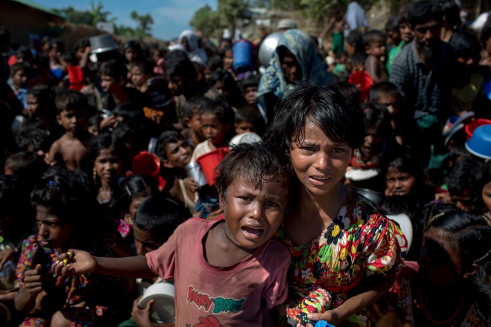 Rohingya refugee children wait in front of a food distribution center in a refugee camp in Bangladesh. 