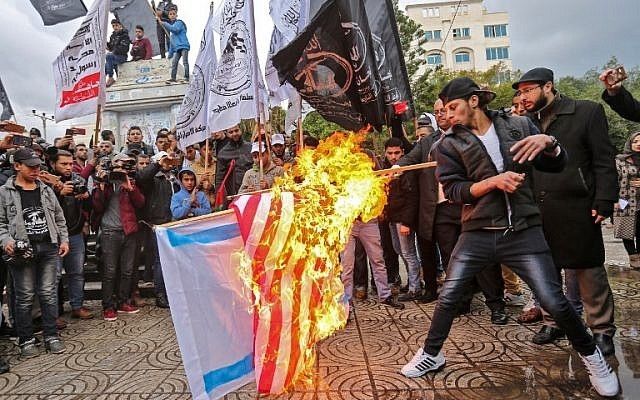 Palestinian protesters burn the US and Israeli flags in Gaza City on December 6, 2017 (Times of Israel) 