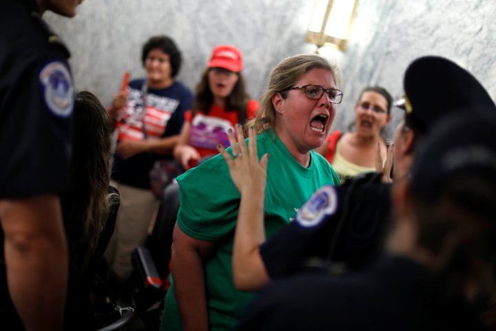 Capitol police detain a demonstrator as the Senate Finance Committee holds a hearing on repealing and replacing the Affordabl
