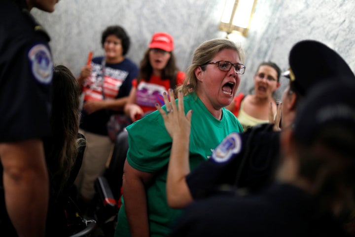 Capitol police detain a demonstrator as the Senate Finance Committee holds a hearing on repealing and replacing the Affordable Care Act. September 25, 2017.