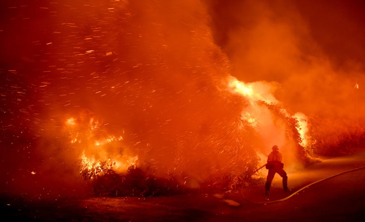 A firefighter battles the Thomas fire in the town of La Conchita early Thursday morning.