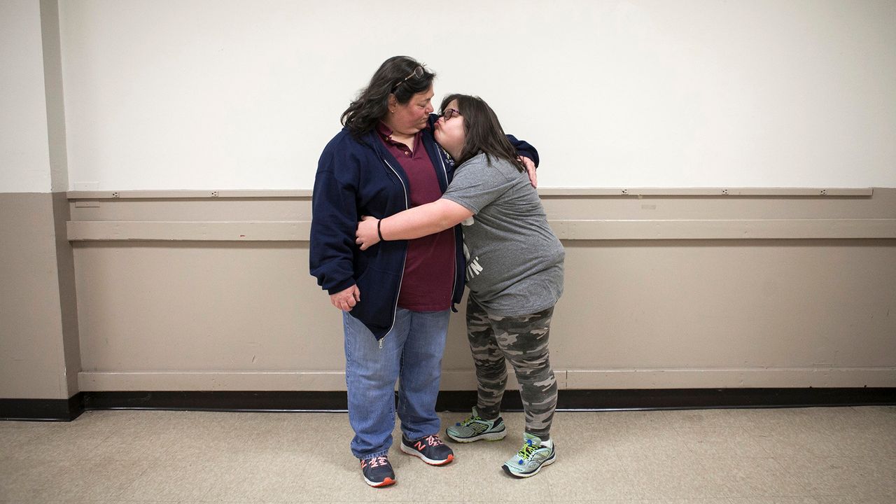 Marjorie Guldan and her daughter Rebecca, 14, hug after the Deer Park 4-H Club holiday party.