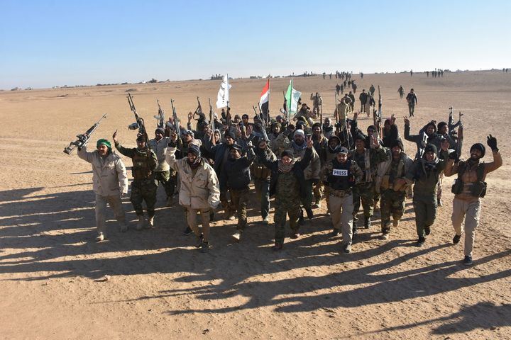 Members of the Hashed al-Shaabi paramiliatries celebrate after Iraq's Prime Minister declared victory in the war against IS