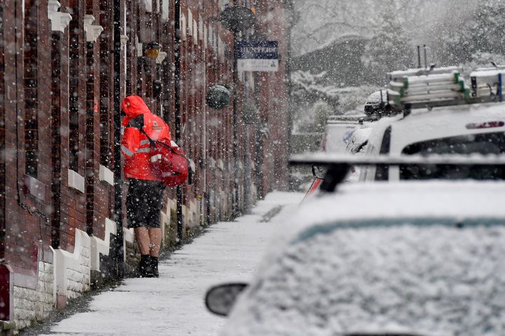 A rather brave postman wearing a pair of shorts delivers mail in Stalybridge, Greater Manchester