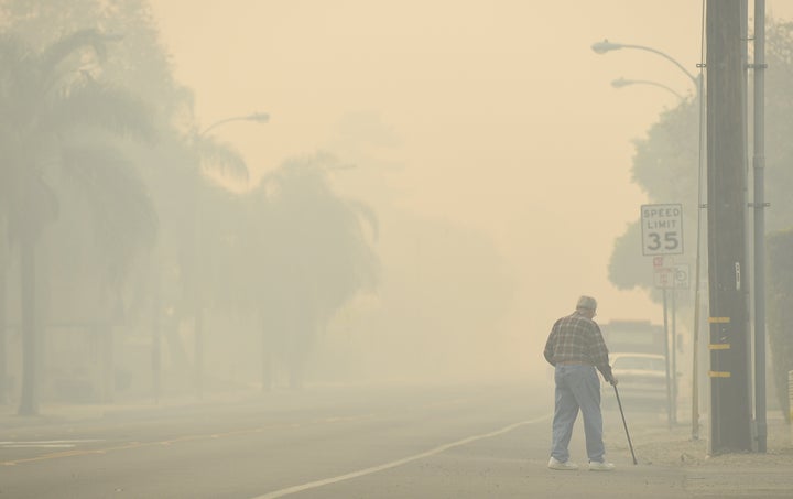 A man walks along Ventura Avenue as the Thomas fire leaves behind smoke on Dec. 8.