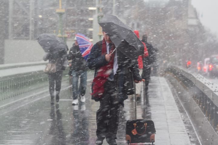 Pedestrians struggle to cope with the snow and sleet conditions on Westminster Bridge on Monday morning