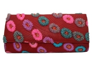 A timeless piece, this clutch features intricate details such as hand-sewn beads.