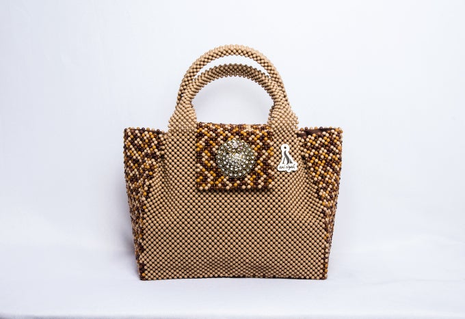 <em>A neutral purse in different shades of brown and gold embellished with a touch of silver exudes effortless glamour.</em>