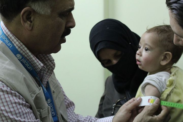 UNICEF Nutrition Officer, Mohammad Younus, screens a child for malnutrition at Al Kahef hospital in Kafr Batna