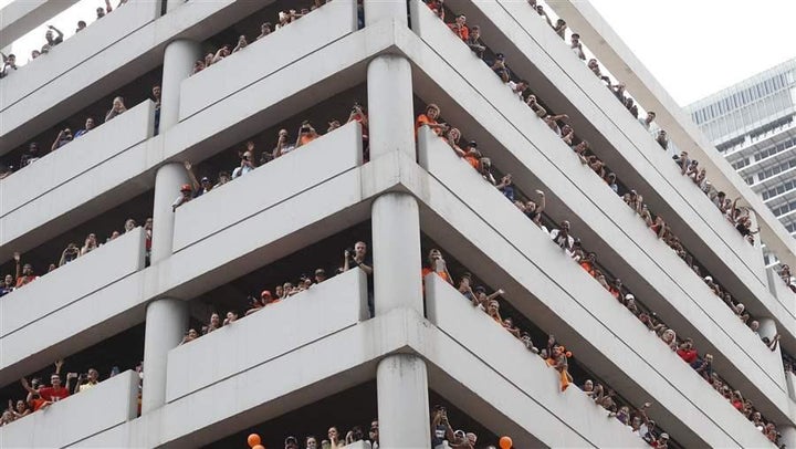 <p>Astros fans watch from a parking garage during a parade honoring the World Series champions in Houston. The rise of ride-hailing services and autonomous cars may make huge downtown garages a thing of the past.</p>