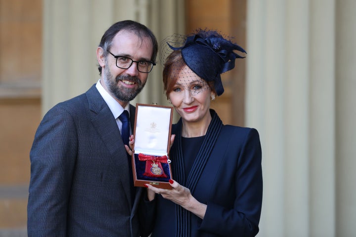 J.K. Rowling, accompanied by her husband Neil Murray, poses with her medal.