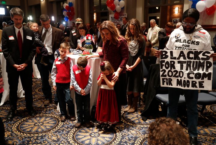 Supporters pray Tuesday during the invocation at Republican U.S. Senate candidate Roy Moore's election night party in Montgomery, Alabama.