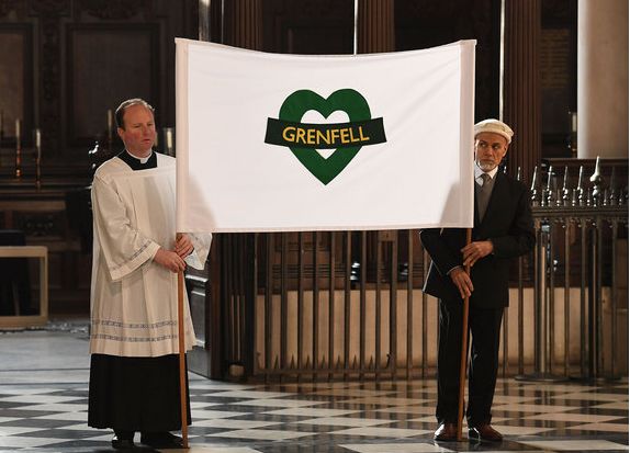 A banner at carried by Father Gerald Skinner and local imam Fahim Mazhary
