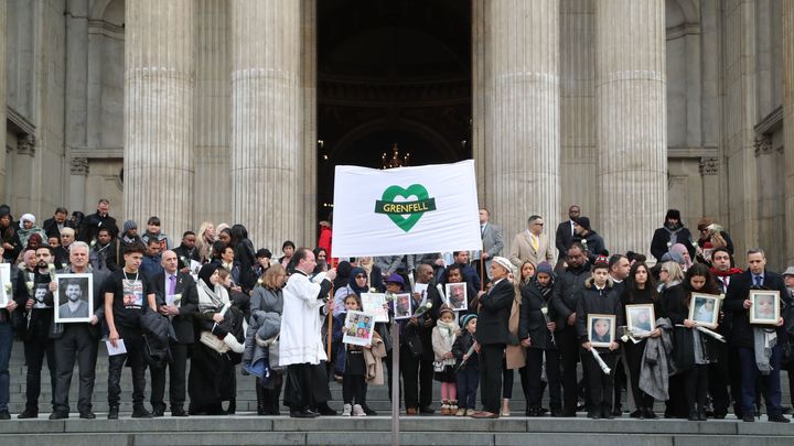 Survivors and the bereaved clutched white roses underneath the Grenfell Heart banner 