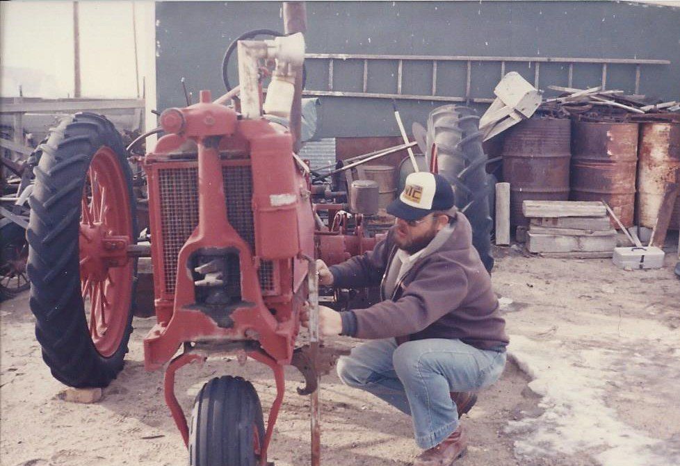 Jim Spencer works on a tractor in the 1980s.