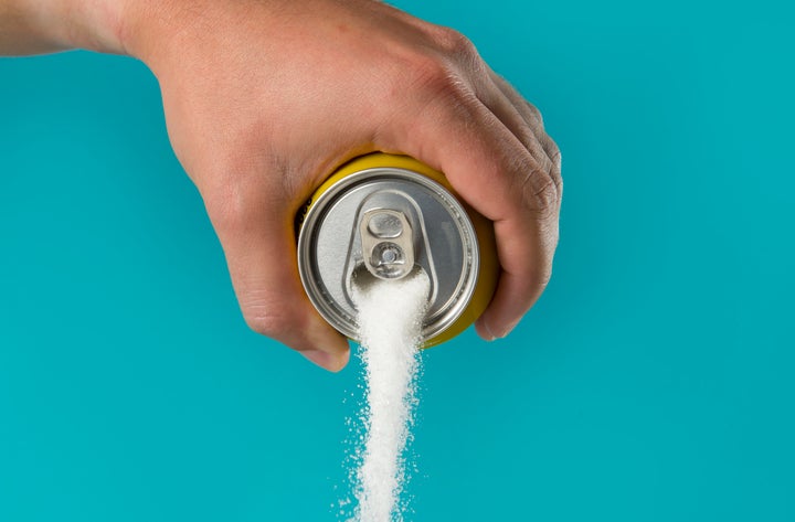 man hand holding lemon refresh drink can pouring sugar stream in sweet and calories content of soda and energy drinks concept in unhealthy nutrition and diet concept