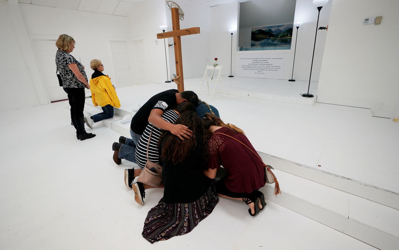 People pray together inside the First Baptist Church of Sutherland Springs, Texas, where a shooter killed 26 people.