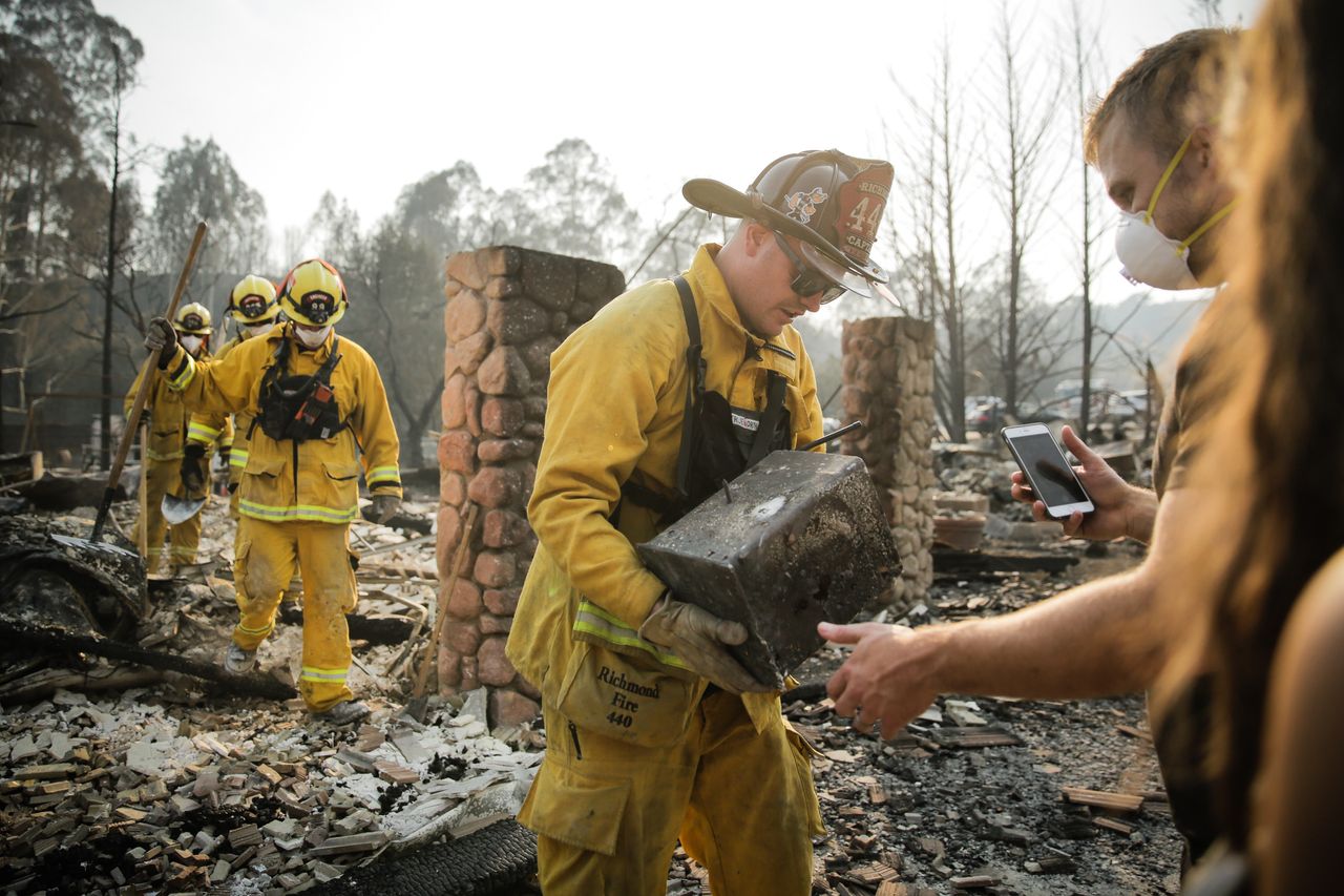 Firefighters help residents of Santa Rosa, California, who lost their homes in devastating wildfires.