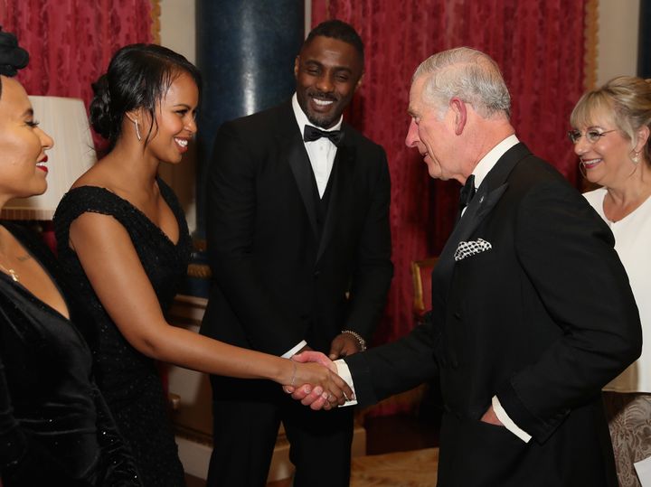 Prince Charles greets Sabrina Dhowre as Idris Elba looks on.