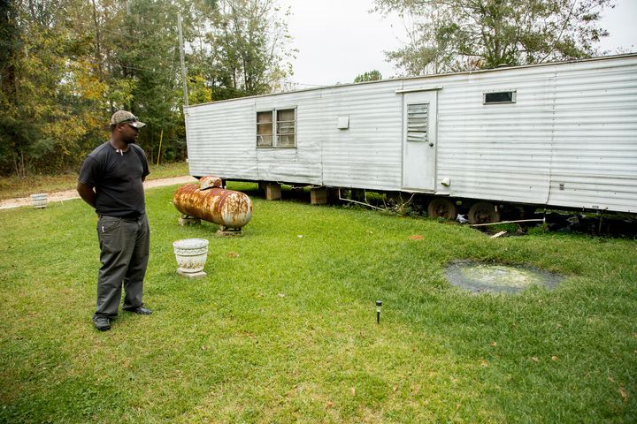 Community activist Aaron Thigpen examines raw waste pooling next to a mobile home in Lowndes County, Alabama. 