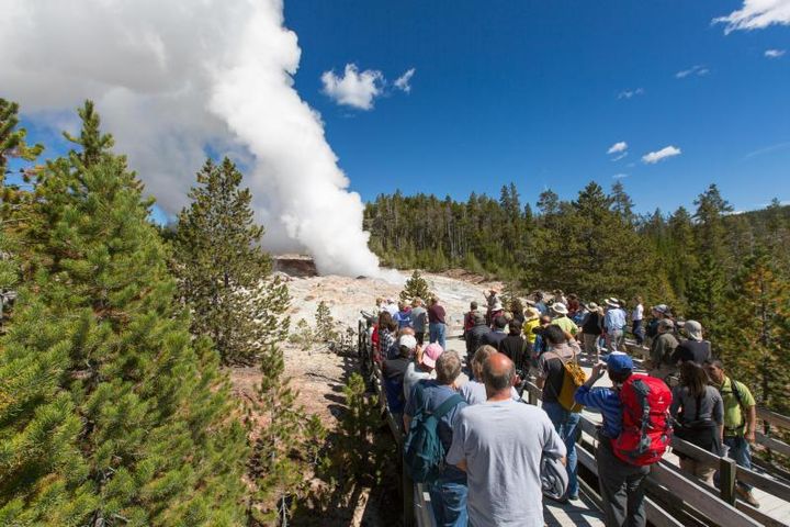 Visitors observe the steam phase at Steamboat Geyser, Yellowstone National Park.