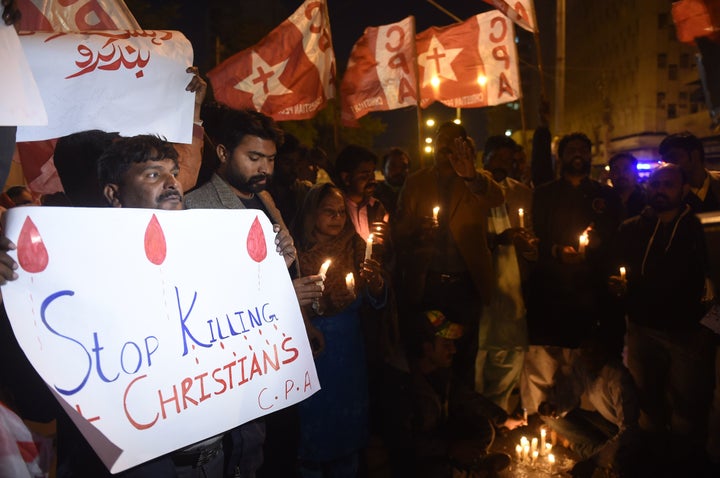 Pakistani Christians hold banners and lighted candles during a protest in Karachi on December 17, 2017, after a suicide bombe