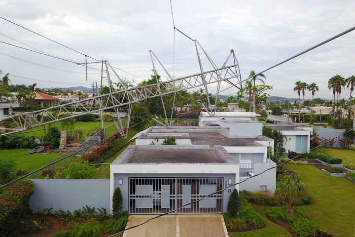 A power line tower, downed by Hurricane Maria, is seen resting on top of a house in San Juan, Puerto Rico, on Nov. 7.