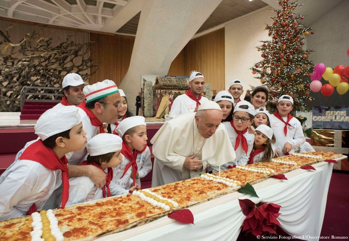 Pope Francis blows on a candle to celebrate his birthday during a special meeting at Paul VI hall at the Vatican on Dec. 17, 2017.
