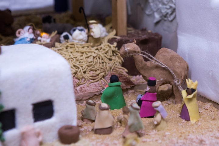 Shepherds and three wise men approach the manger scene.