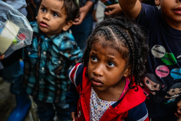 Children wait for food in soup kitchens that provide free food on the streets to counteract the food crisis in May 2017
