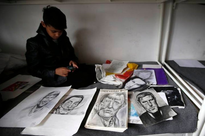 <p><em>Farhad Nouri, “The Little Picasso”, sitting among some of his portraits.</em></p>