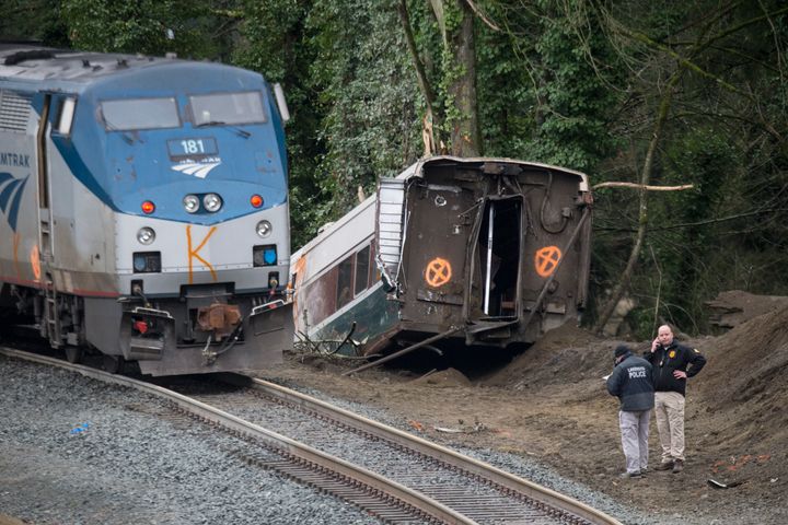 Officers at the scene of the derailment, which killed three 