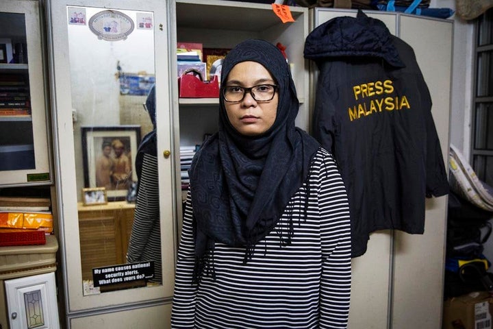 Diyana Kamalludden, 36, stands in front of a windbreaker belonging to her late husband, a cameraman who died f