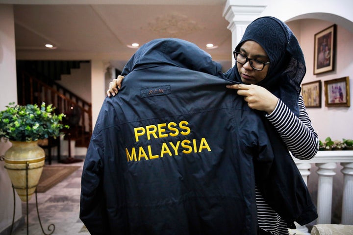 Diyana holds up her late husband’s windbreaker.