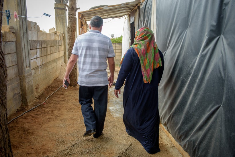 Pastor Miled and Fatima, a Syrian refugee, walk through a refugee settlement in Lebanon. The two formed a close bond after Fa