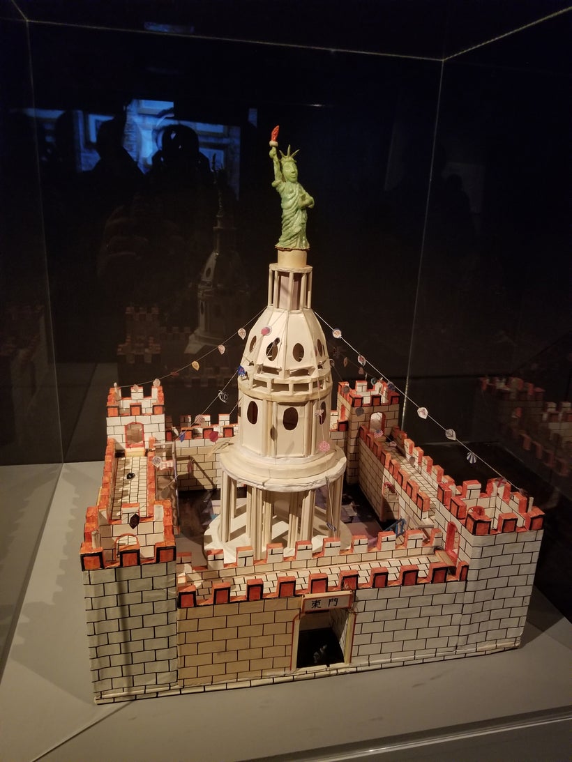 Buddha-faced Statue of Liberty atop the U.S. Capitol Dome inside Chinese city walls.